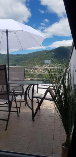 a table and a chair and an umbrella on a balcony at La Terrazza sul Lago di Como con garage in Blevio