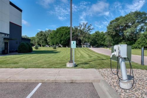 a parking meter next to a pole in a park at Best Western Plus Saint Peter in Saint Peter