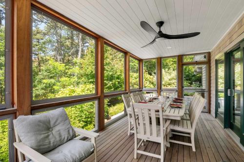 a screened in porch with a table and chairs at Modern Wellfleet Retreat with Stunning Outdoor Spaces in Wellfleet