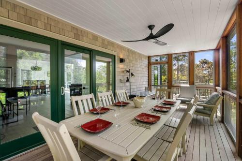 a dining room with a table and a ceiling fan at Modern Wellfleet Retreat with Stunning Outdoor Spaces in Wellfleet