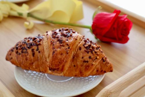 a piece of bread in a bowl on a table with roses at Apartman TAUNUS in Kopaonik