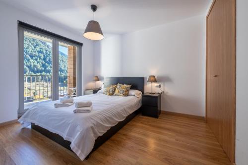 a bedroom with a large bed and a large window at Barthe Holidays I Apartamento moderno en Arinsal 4PAX a pie de pistas, balcón con vistas y parking I Bosque in Arinsal