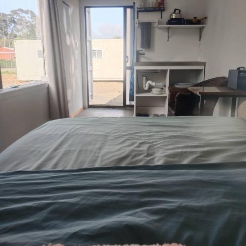 a bed in a room with a large window at Qing he Farm with Own Access in Auckland