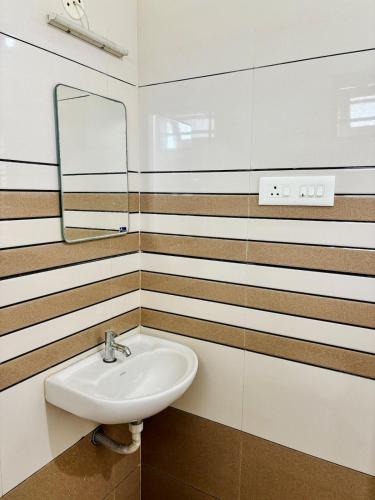 a bathroom with a sink and a mirror at Spacious, Sweet home in town, in Kakkanad
