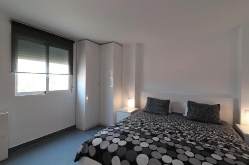 Un dormitorio con una cama con dos almohadas y una ventana. en Oliva Nova MET & BEACH Apartment, en Casas Devesa