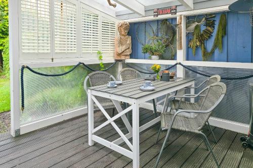 a porch with a table and chairs on it at Ferienhaus "Kleine Auszeit" in Zingst in Zingst