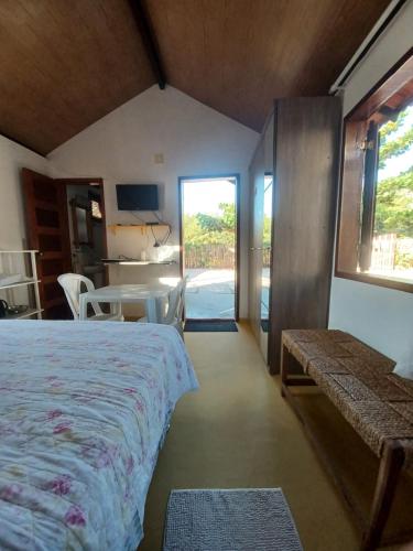 a bedroom with a bed and a table and a window at SwissChalet Hp-Kite in Barra Grande