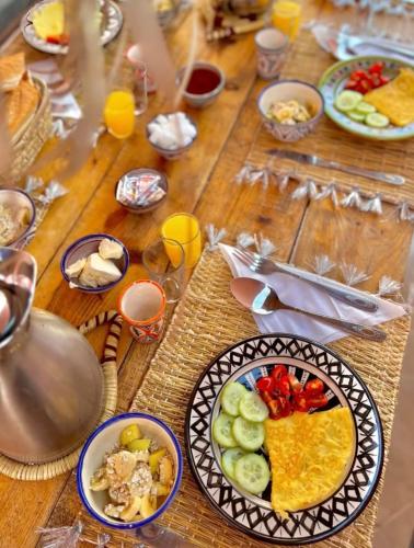 a wooden table with plates of food on it at Imsouane Vibe Surf house in Imsouane