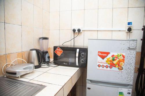un bancone cucina con forno a microonde e frigorifero. di Ndoto apartment a Ukunda