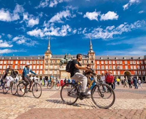 a man riding a bike in front of a building at Hostel Almansa in Madrid