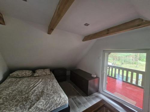 a bedroom with a bed and a large window at Domek u Kasi w Siemianach z balią i sauną in Siemiany