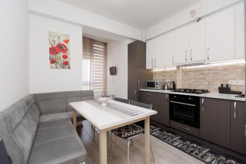 a kitchen with a couch and a table in a room at Modern Apartment in Chișinău Testimetianu in Chişinău