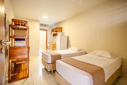 a bedroom with two beds and a refrigerator at Villa das Palmeiras Jeri in Jericoacoara