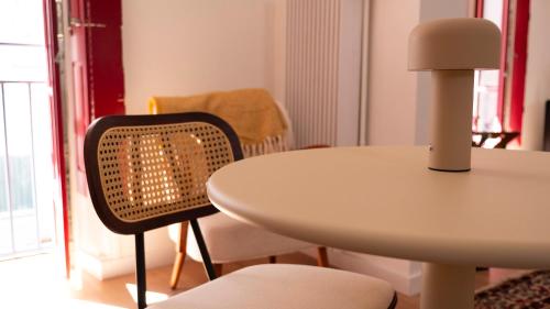 a white table and a chair next to a table and a table at Le Mercœur - studio cosy - hyper centre Nantes in Nantes