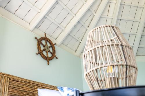 a rattan chair and a clock on a ceiling at Fragata Island House in Isla Grande