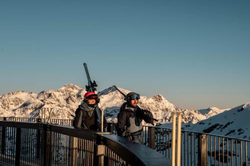 two people standing on a bridge with mountains in the background at Barthe Holidays I Apartamento amplio en Andorra 6PAX I Céntrico y luminoso I Central Park in Escaldes-Engordany