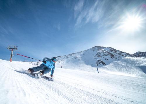 a man riding a snowboard down a snow covered slope at Barthe Holidays I Apartamento moderno en Arinsal 4PAX a pie de pistas, balcón con vistas y parking I Bosque in Arinsal