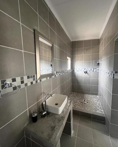 Un baño grande con lavabo y ducha. en The Vibe Venue, en Tierpoort
