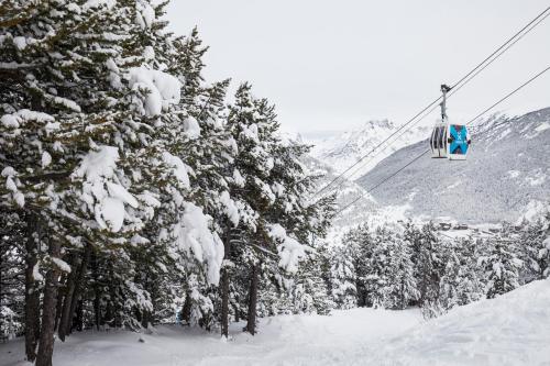 a ski lift with snow covered trees on a mountain at Barthe Holidays I Apartamento moderno 5PAX en Arinsal I Ideal para familias, Parking, Pet friendly I Coma Pedrosa in Arinsal