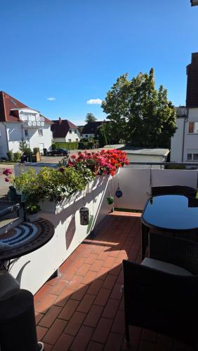 a balcony with red flowers on a white wall at Wohnung in Graal-Müritz nahe Strand in Graal-Müritz