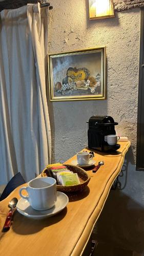 un tavolo di legno con tazze e piattini sopra di Terrazas Suite a Potrero de Garay