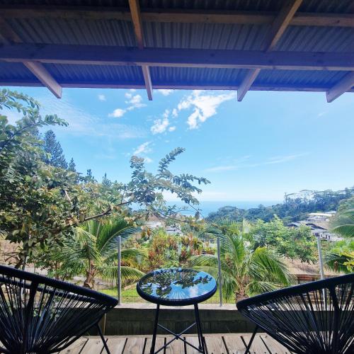 a view from a patio with two chairs and a table at Fare Toahana, logement chez l'habitant in Faaa
