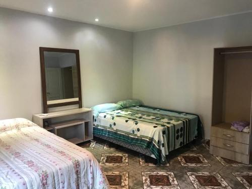 a bedroom with two beds and a mirror at Casa SIÓN in Ituzaingó