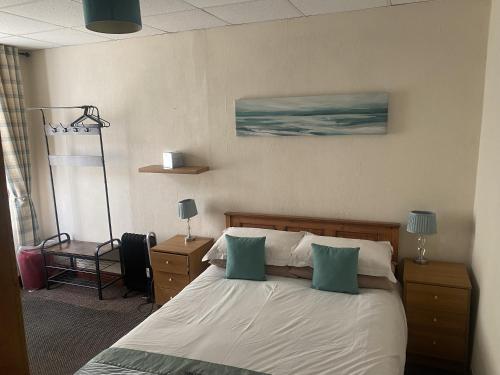 Un dormitorio con una cama con dos almohadas verdes. en Evanescent- Adult Only, en Blackpool