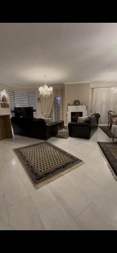 a living room with couches and a chandelier at Plex House in Tríkala
