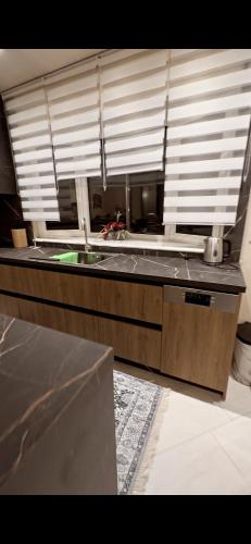 a kitchen with a counter with a sink and a window at Plex House in Tríkala