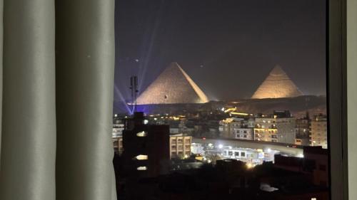 a view of the pyramids of a city at night at ROFY VIP Apartment in Cairo