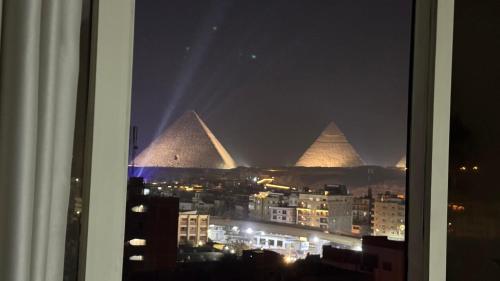 a view of the pyramids from a window at night at ROFY VIP Apartment in Cairo