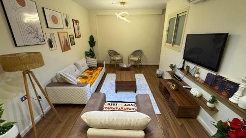 a living room with a couch and a tv at ROFY VIP Apartment in Cairo