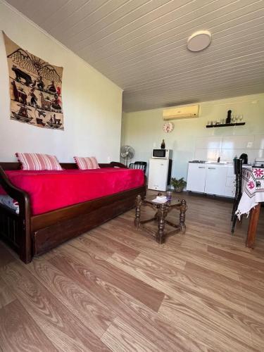 Cette chambre comprend un grand lit avec une couverture rouge. dans l'établissement Da Fortuna 1, à Barra de Portezuelo