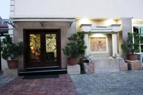 a house with a door with potted plants in front of it at Adna Hotel in Lagos