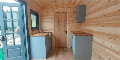 ダンフリーズにあるBurnside of Ae Glamping Shepherd's Hutのログキャビン内のキッチン(シンク付)