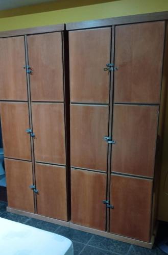 a set of four wooden storage cabinets in a room at Pousada Village Hostel in Petrópolis