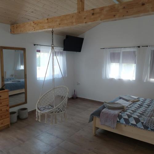 a bedroom with a swinging bed and a chair at Casuța Casa Dia in Cisnădie