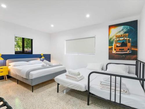 マイアミにあるMiami Escape Studio W Kitchen & Heated Poolのベッドが2つとトラックの絵が飾られた寝室