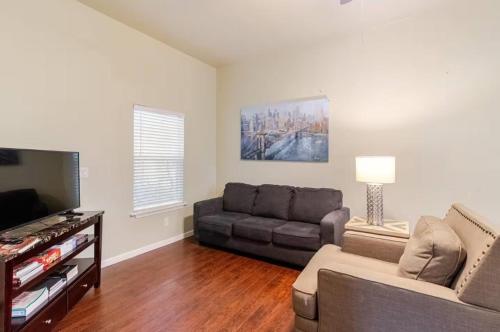 a living room with a couch and a flat screen tv at Private Rooms in San Antonio Home 5 mins to downtown in San Antonio