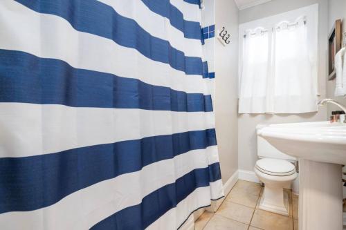 La salle de bains est pourvue d'un rideau de douche bleu et blanc. dans l'établissement 3BR, 2BA house steps from historic Jonesborough, à Jonesborough