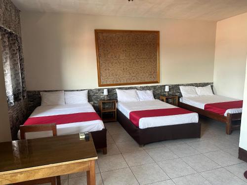 a hotel room with two beds and a table at La Posada del Cauchero Hotel & Suites in Iquitos