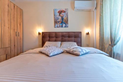 ズラティボールにあるZlatibor Villa, Sauna, Free Parking near Lake and Ski Centerの大きなベッドと2つの枕がある寝室