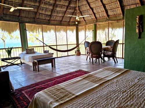 a bedroom with a bed and a table and chairs at Casa Maria en La Manzanilla in La Manzanilla