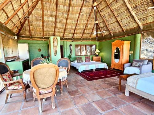 a room with two beds and a table and chairs at Casa Maria en La Manzanilla in La Manzanilla