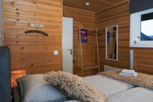 a bedroom with a bed in a room with wooden walls at 3ART recreation in Tromsø