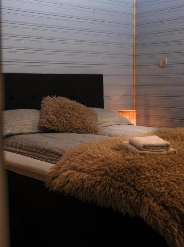 a bed with a brown blanket and pillows on it at 3ART recreation in Tromsø