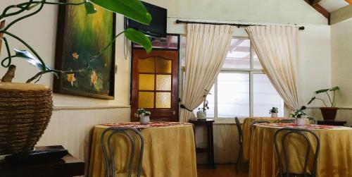 a row of tables in a room with a window at Hostal Dinamarca in Temuco