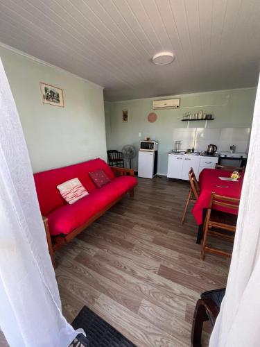 ein Wohnzimmer mit einem roten Sofa und einer Küche in der Unterkunft Da Fortune 2 in Barra de Portezuelo