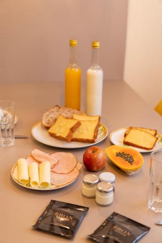 Flats Chateau Campos do Jordão في كامبوس دو جورداو: طاولة مع أطباق من الطعام وزجاجات من الحليب